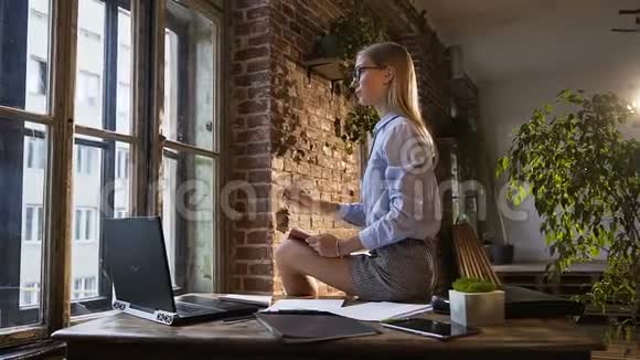 美丽迷人的白种人女孩坐在桌子上手里拿着记事本和笔创造性的个性坐在视频的预览图
