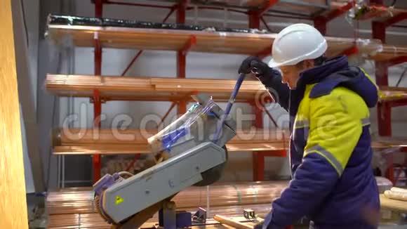 在工厂里用圆锯工作的安全帽工人建筑工人打磨锯金属视频的预览图