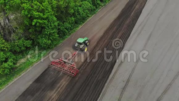 空中勘测俯视图春天拖拉机耕耘挖掘土壤拖拉机犁地自动分蘖视频的预览图