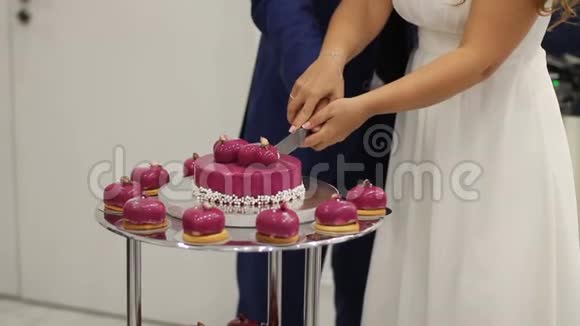 婚礼接待处的新娘和新郎切红心的婚礼蛋糕视频的预览图