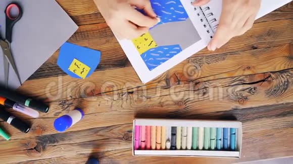 将年轻女性用蜡笔在笔记本上画出来在工作场所室内的办公桌前做原始拼贴画视频的预览图