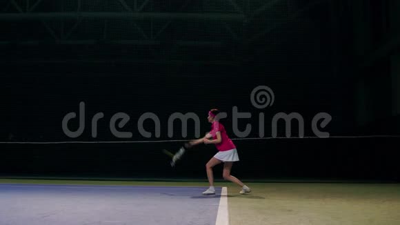一个穿着粉红色T恤和白色裙子的女人在网球比赛中打球网球运动员学会打球视频的预览图
