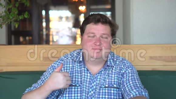 一个身材魁梧的帅哥在咖啡馆或餐馆里竖起大拇指视频的预览图