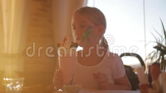 可爱的小女孩在咖啡馆里吃奶昔和甜点视频的预览图