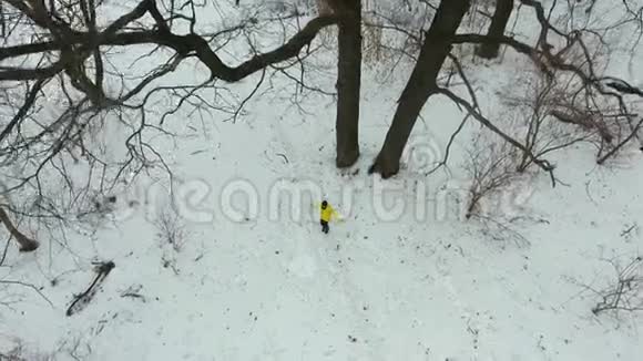 冬季森林中带绳跳跃的黄衣长胡子运动员视频的预览图