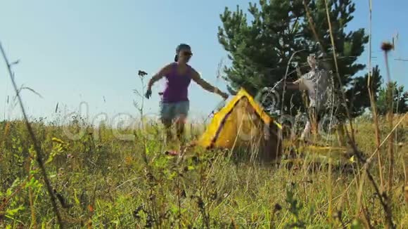 一男一女在林间空地上搭帐篷时光飞逝视频的预览图
