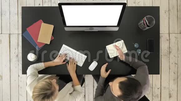 两位经理在电脑屏幕上讨论项目白色显示器视频的预览图