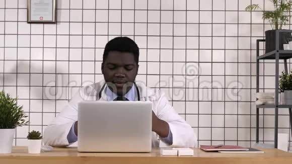 医生在看新的平板电脑检查笔记本电脑上的信息视频的预览图