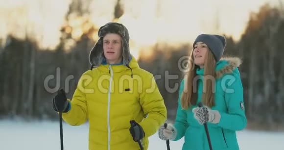 在冬季森林滑雪行走期间一个有爱心的年轻人帮助受伤的女友的完整画像视频的预览图