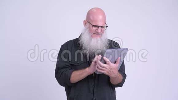 成熟的秃头男人一边说话一边用数码平板电脑视频的预览图