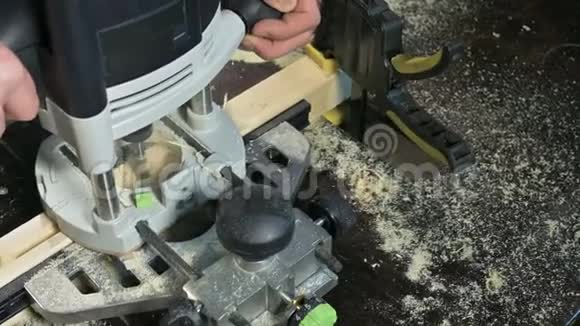 木工在家庭车间用手动电动切割机进行手工操作的手整理木制部件视频的预览图