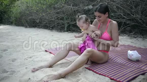 妈妈把女儿的泳衣放在海滩上4k视频的预览图