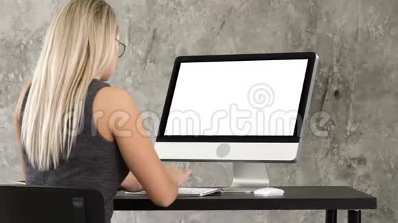 女商人坐在办公室的办公桌前用桌面显示器工作白色显示器视频的预览图