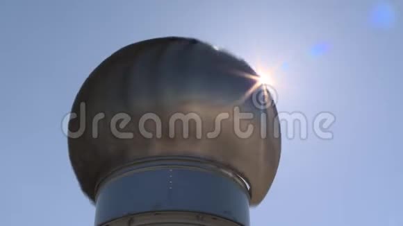 在蓝天背景下可见的圆形通风机旋转和太阳射线束视频的预览图