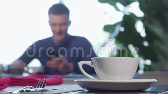 一杯咖啡或茶放在桌子上男人在后台享用早餐视频的预览图
