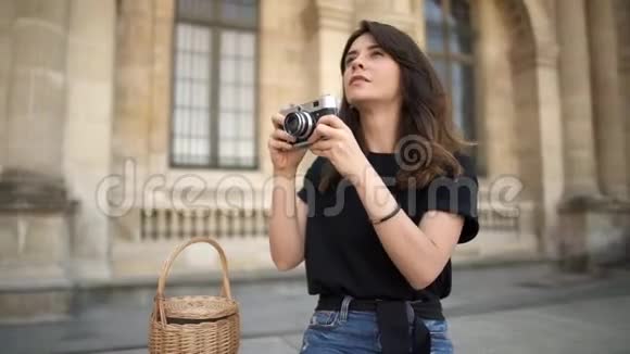巴黎漂亮的女人在背景上用胶卷相机拍照巴黎的旧建筑背景视频的预览图