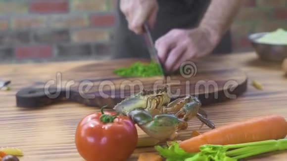 活蟹在海鲜餐厅的桌子上爬行一边做饭厨师带海蟹做海鲜视频的预览图