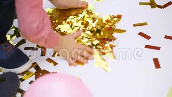 特写孩子们手在玩着金光闪闪的东西从饼干里冒出的金色的火花节日的金属装饰品视频的预览图