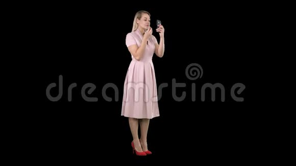涂口红的女人看着手机阿尔法频道视频的预览图