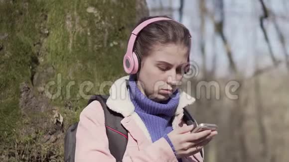 带着手机在森林里旅行的女孩视频的预览图