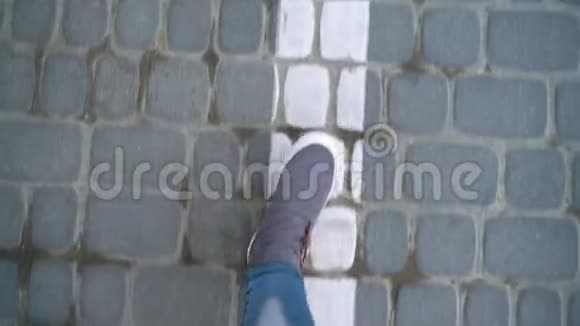 在人行道上行走的灰色运动鞋中女性腿的俯视图视频的预览图