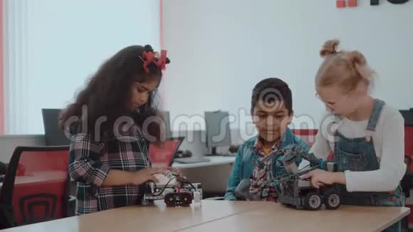 混合种族的创造性的孩子在学校从事科技项目学生男孩和女孩玩耍和学习视频的预览图