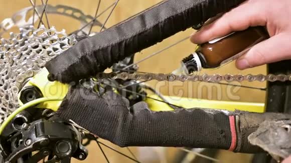 在修理自行车的车间里主人用润滑脂润滑链条自行车修理视频的预览图
