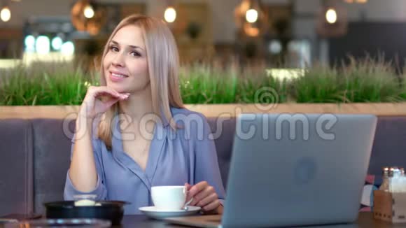 咖啡厅坐在桌边享受休息的年轻漂亮女人的中景照片视频的预览图