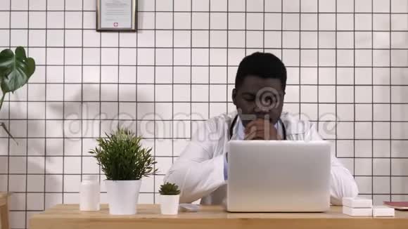 非裔美国医生在电脑和笔记本电脑上工作读一些东西视频的预览图