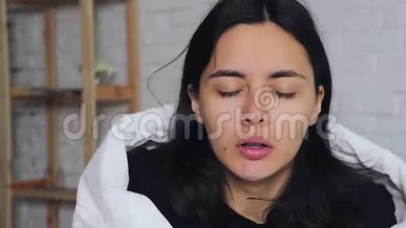 感冒季节流鼻涕生病的女孩躺在床上用手帕打喷嚏视频的预览图