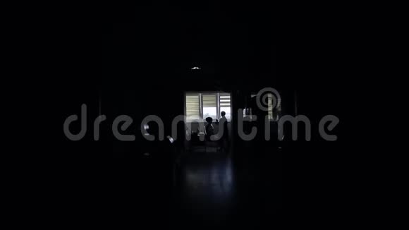 黑暗的走廊走廊的尽头是一个明亮的房间设计师在里面做化妆女孩视频的预览图