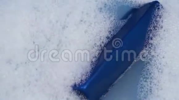 一罐蓝色的洗发水漂浮在泡沫的水中洁和个人关怀的理念视频的预览图
