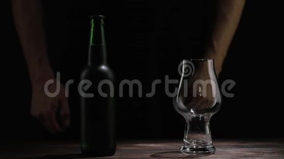 男人把啤酒倒进桌子上的玻璃杯里视频的预览图