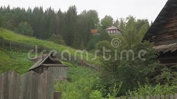 古老的俄罗斯村庄有古老的木屋乡村道路和小河岸上绿油油的青草视频的预览图