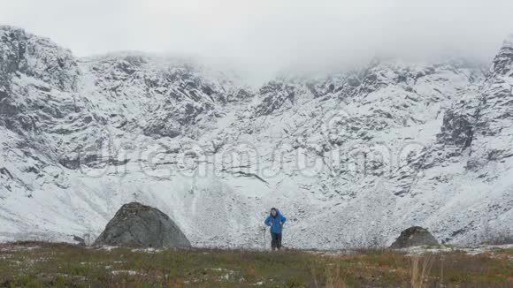 一个背着背包的人走在大山的背景上视频的预览图