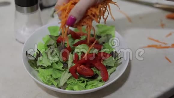 在沙拉中加入切碎的胡萝卜和红椒和生菜沙拉视频的预览图