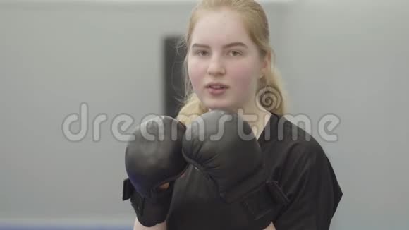 一位戴着拳击手套的年轻女子在镜头前视频的预览图