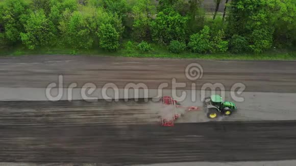 空中勘测俯视图春天拖拉机耕耘挖掘土壤拖拉机犁地自动分蘖视频的预览图