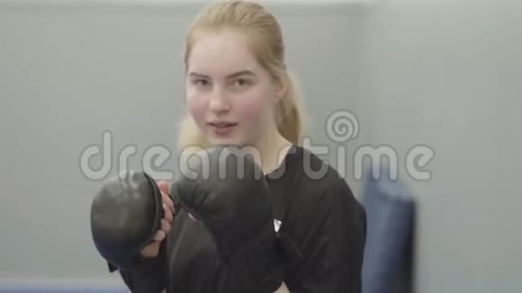 一位戴着拳击手套的年轻女孩在镜头前视频的预览图