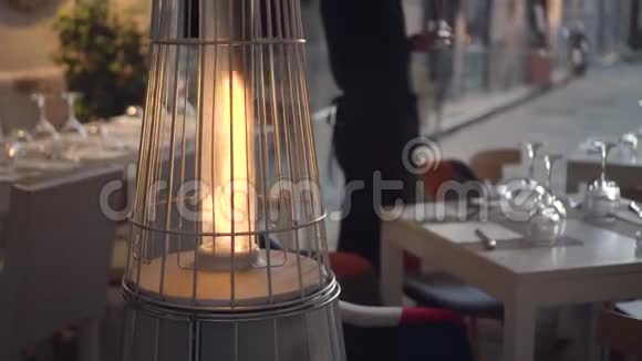咖啡馆里的金字塔形户外燃气加热器服务员点蜡烛视频的预览图