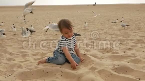 穿着条纹T恤的孩子在海边沙滩上奔跑视频的预览图