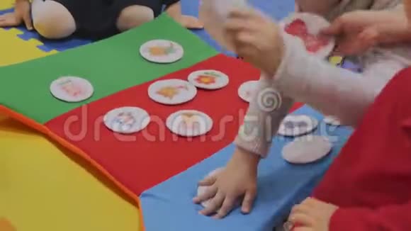 动画师和孩子们一起在孩子们的房间里玩毛绒贴纸贴上图片只有手是可见的特写的视频的预览图