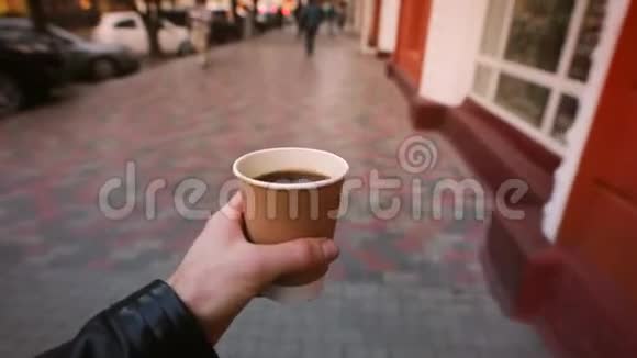 第一人称景观男人在城市大街上喝咖啡杯视频的预览图