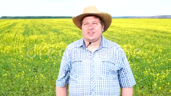 农民站在田野上的肖像在阳光明媚的日子戴着牛仔帽视频的预览图