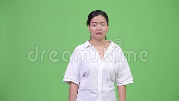 年轻悲伤的亚洲女人一边哭一边竖起大拇指视频的预览图