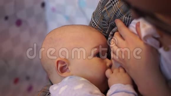 一个十个月大的婴儿在母亲的手中哺乳特写镜头产假婴儿护理视频的预览图