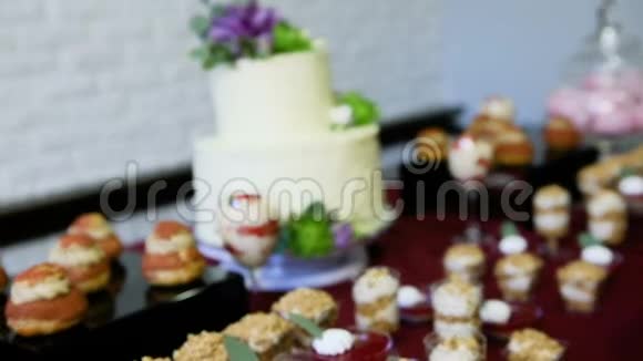 把注意力集中在用糖果桌上的花装饰的白色蛋糕上视频的预览图