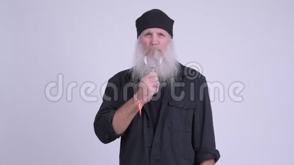 成熟的留胡子的嬉皮士玩放大镜视频的预览图