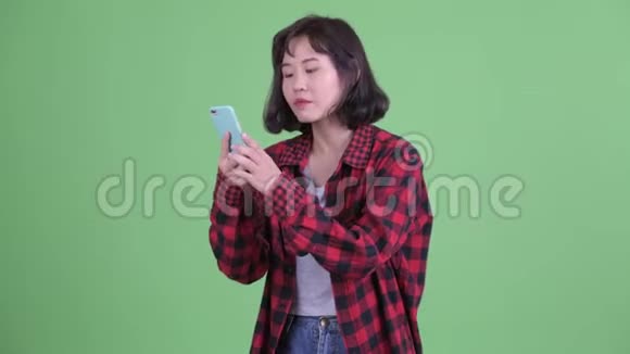 快乐的亚洲时髦女人打电话视频的预览图