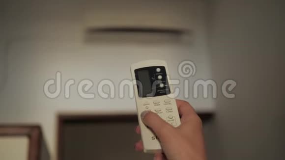 房间内有空调女性操作遥控器带遥控器的酒店配有空调视频的预览图